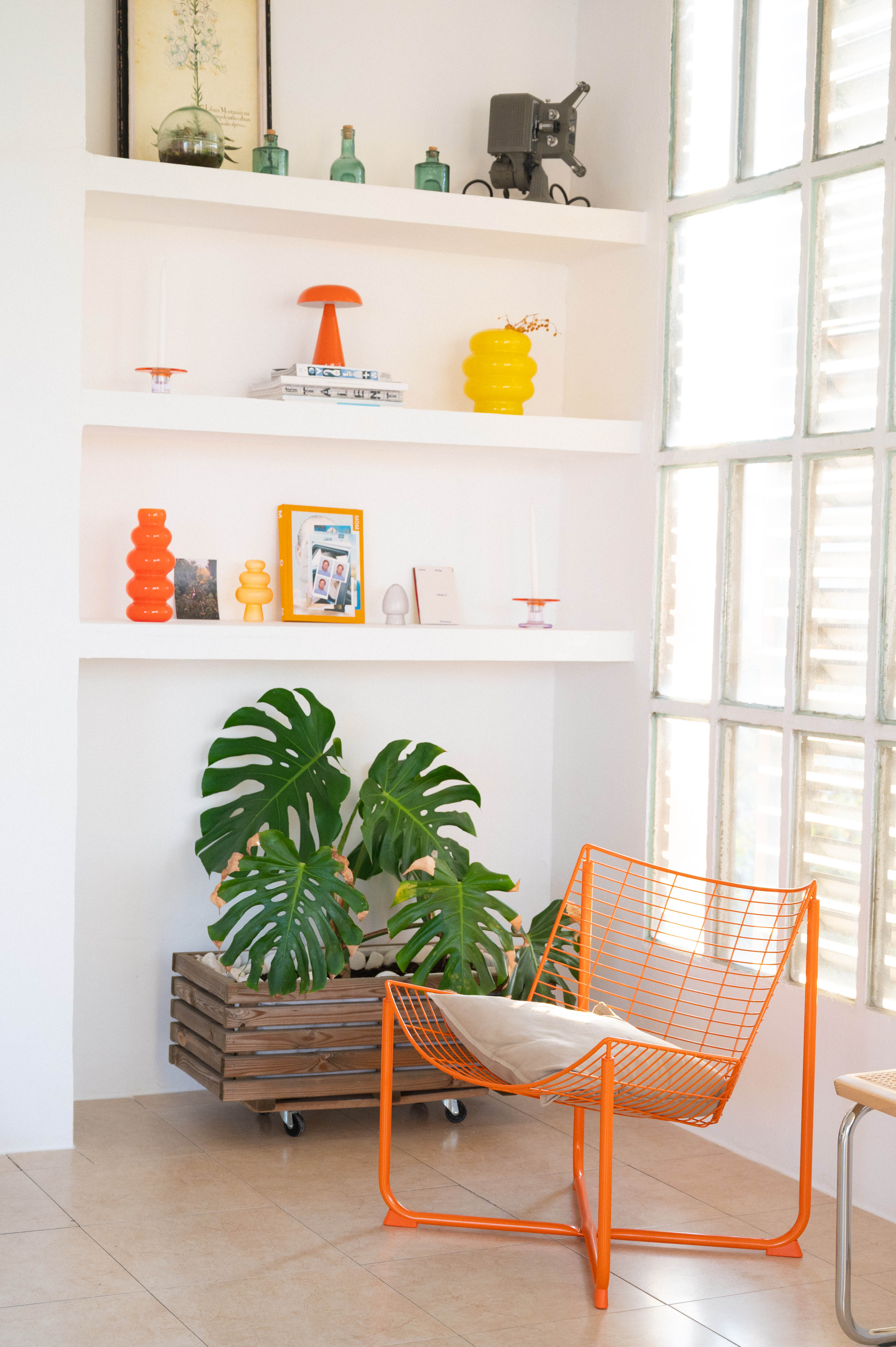 Rincón del estudio con luz natural, estanterías de obra y plantas